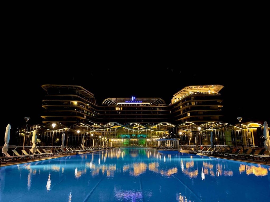 Night view of a luxury integrated resort with illuminated pool, representing Medisa Hospitality’s 12-month IR revenue focus.